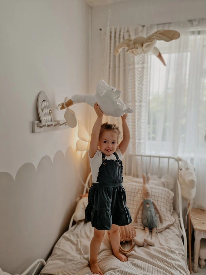 Flying Stork Hanging Decoration, a hanging stork decoration suspended in a child's bedroom. 