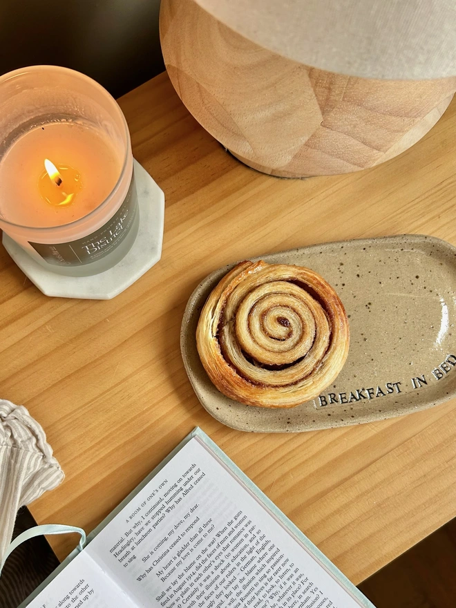 cinnamon swirl on a ceramic plate on a bedside table