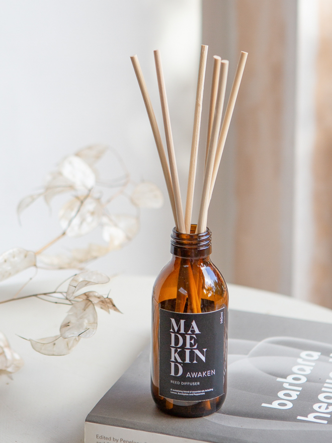 Room diffuser fragranced with essential oils on a side table with dried flowers