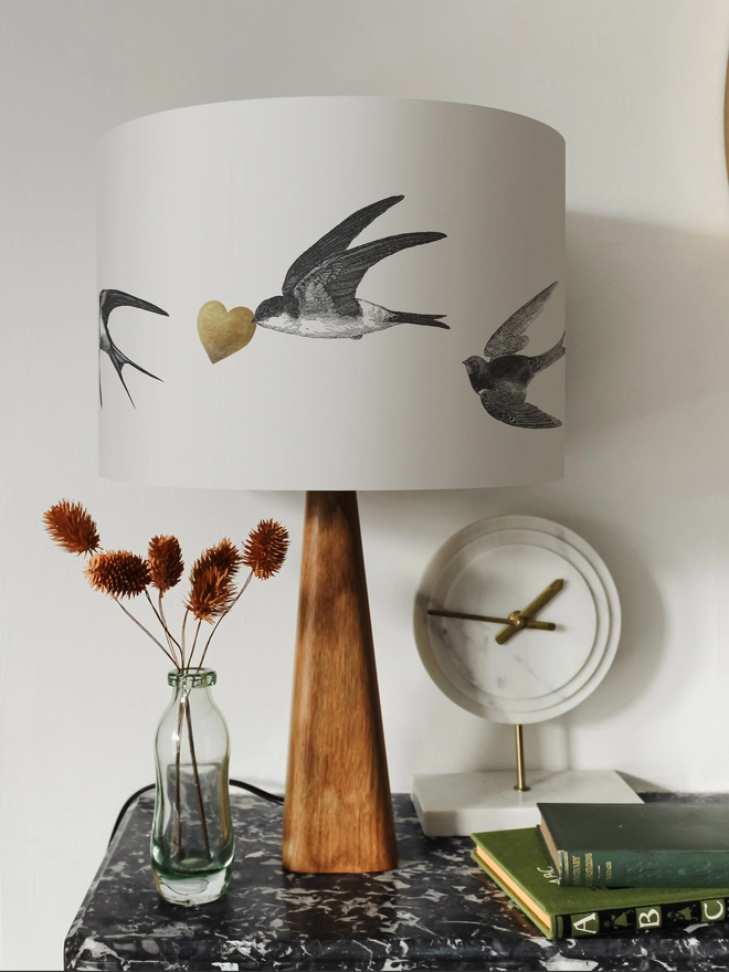 Handmade lampshade featuring graceful flying swallows swooping through a nature-inspired design, adding an elegant touch to any room.