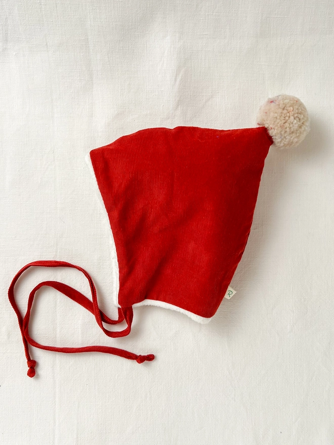 brick red pixie bonnet with wool pom pom