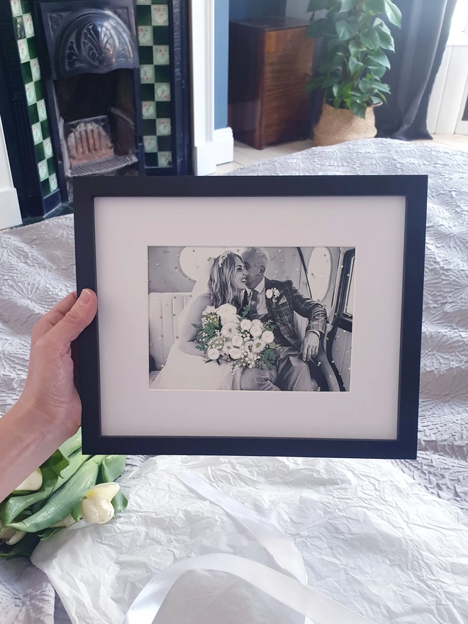 Wedding photo with hand embroidered bouquet and confetti held in black frame
