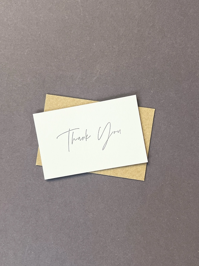 Letterpress printed tiny note illustrated with a thank you in modern calligraphy with a kraft envelope