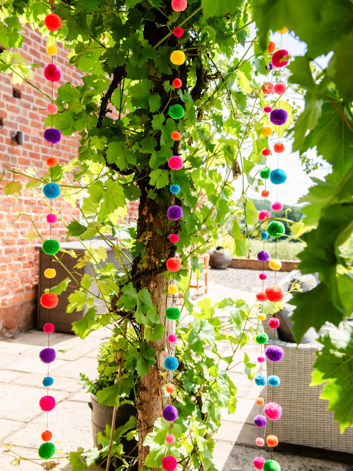 colour combo pom pom garland. a garland of woollen pompoms in rainbow colours.