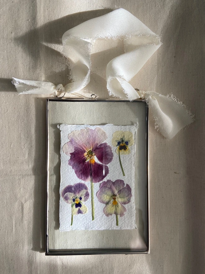 Glass hanging frame with pressed pansy flowers and ivory chiffon ribbon 