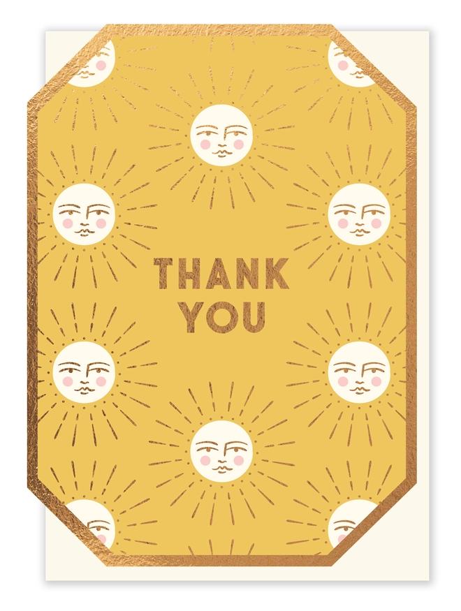 Gold coloured greeting card with die-cut and foiled edges paired with a fleck craft envelope.  The card reads "Thank You" and features pictures of smiling suns.