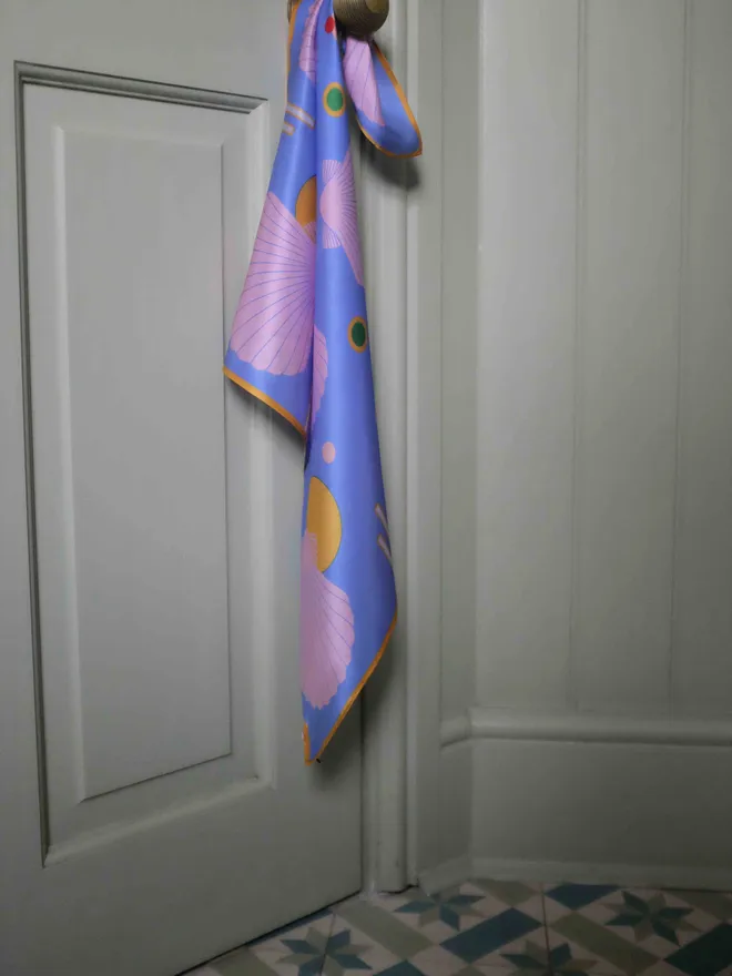 'Sea Shells - Blue and Pink' Silk Scarf tied around a door knob of a white door