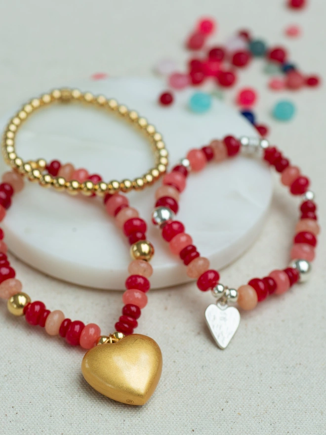 The Bright Side Bead Bracelet in Romeo features vibrant red and soft pink jade beads, creating a joyful pop of colour you’ll reach for every day. Hand-strung on strong stretch elastic and finished with a charm of your choice, this personalised bead bracelet is perfect for stacking or wearing solo. A playful, mood-lifting piece designed for effortless everyday style and thoughtful gifting.