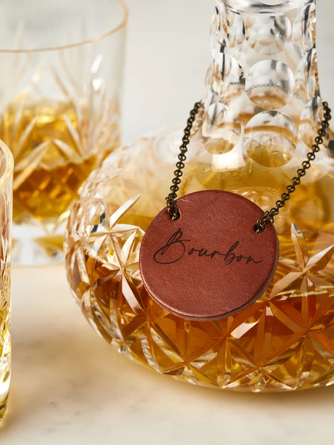 Cognac leather engraved decanter tag with script text.