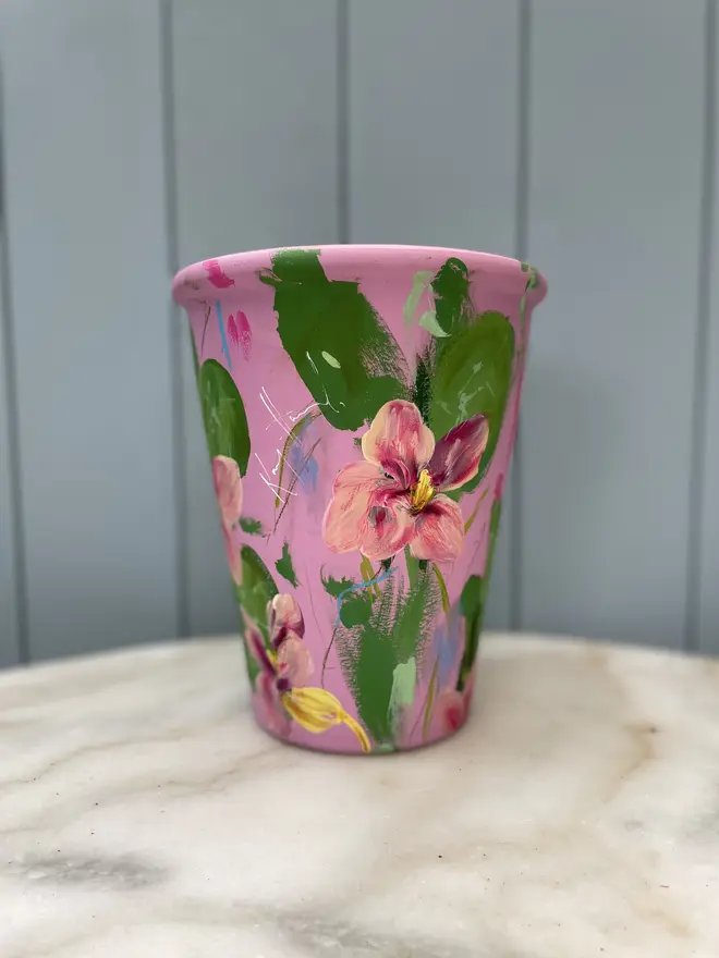 Unique hand-painted terracotta pot featuring pink Nasturtium on a pink background