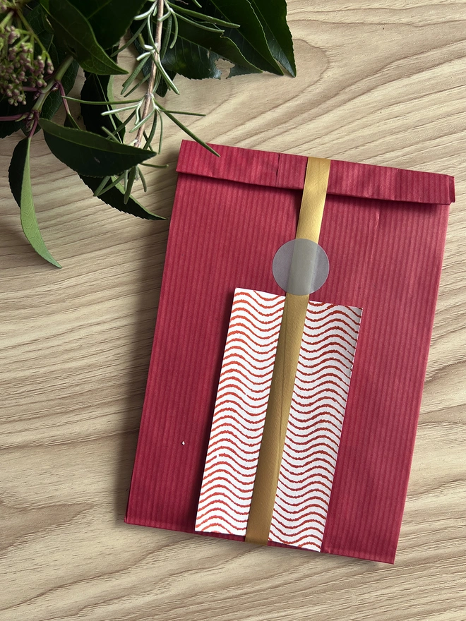 Optional gift wrap of red paper, ribbon and patterned gift note