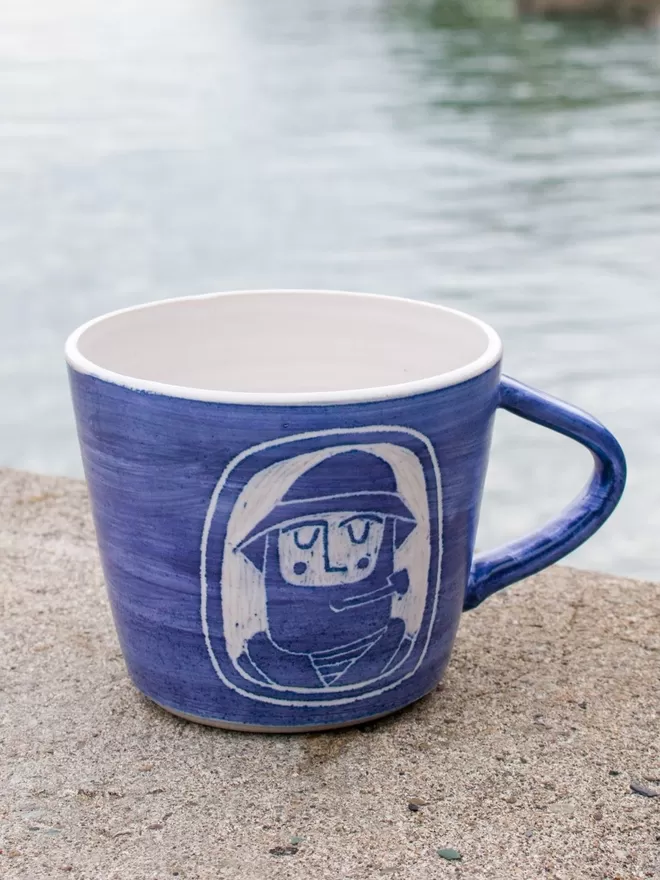 Laura Lane Ceramics Front facing fisherman mug with pipe.