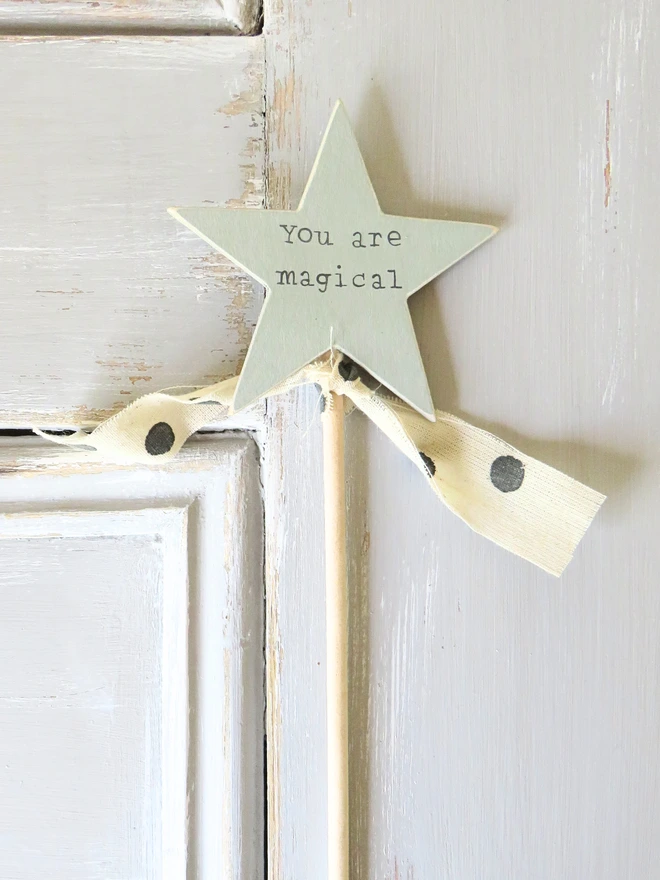 wooden star shaped cake topper with hand painted message and ribbon detail