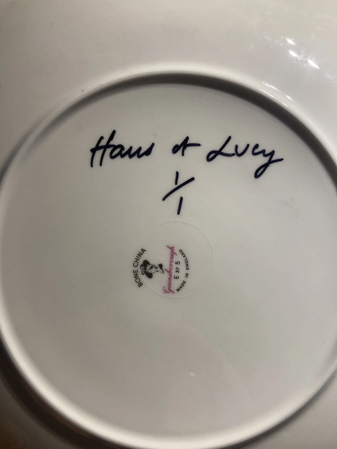 The artist's signature on the base of the plate