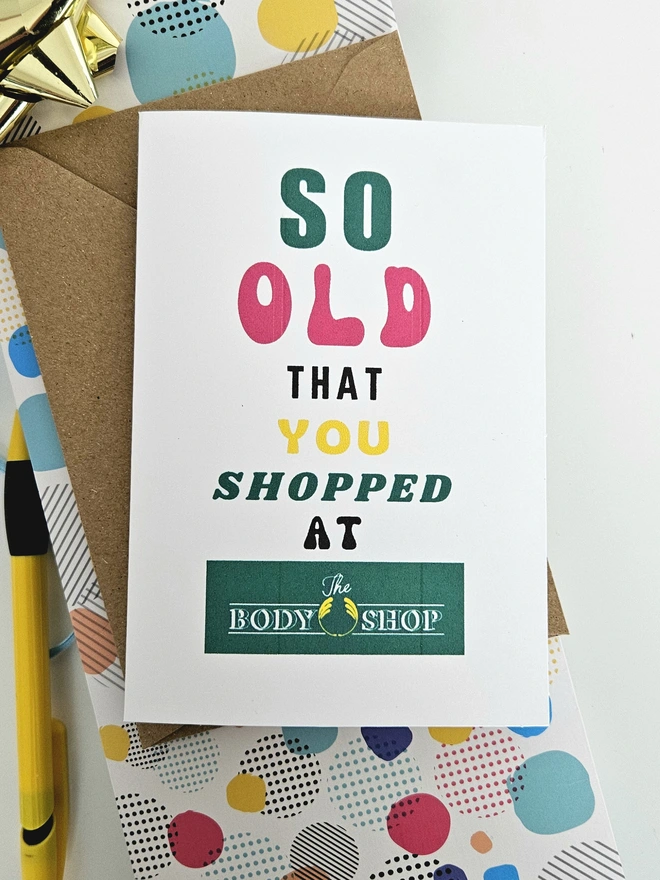 A photograph of the front of a humorous A6 greeting card illustrated using brightly coloured text and the retro shop logo. The text says so old you shopped at The Body Shop