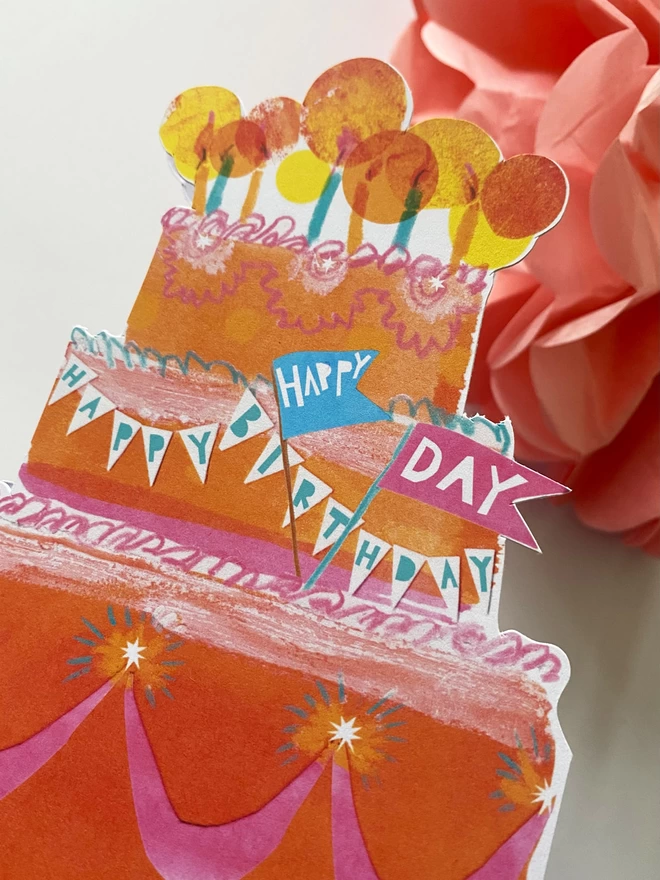 Happy Birthday Cake custom-shaped illustrated card by Esther Kent, in the shape of an extravagent 80s oragne, pink and turqoise layered v=cake, topped with glowing candles