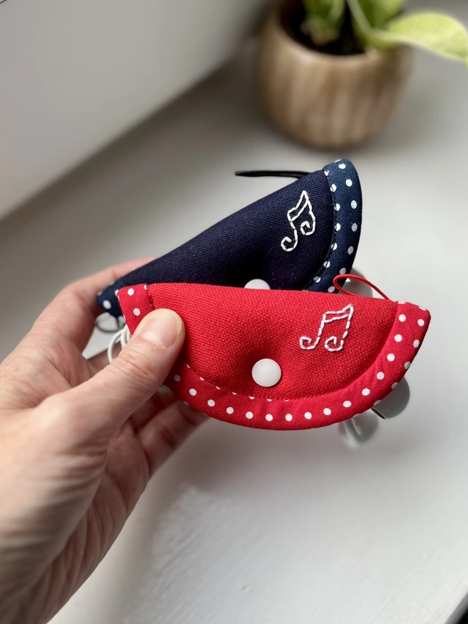 2 small cotton earphone cases with snap closure, embroidered with musical notes.