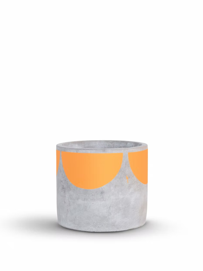 sunny concrete plant pot. a grey plant pot with an orange half sun pattern painted around the top rim.