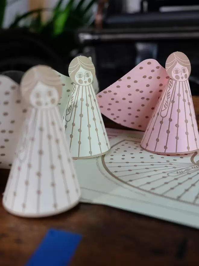 Set of three illustrative angel 3-D cards standing on flat card.