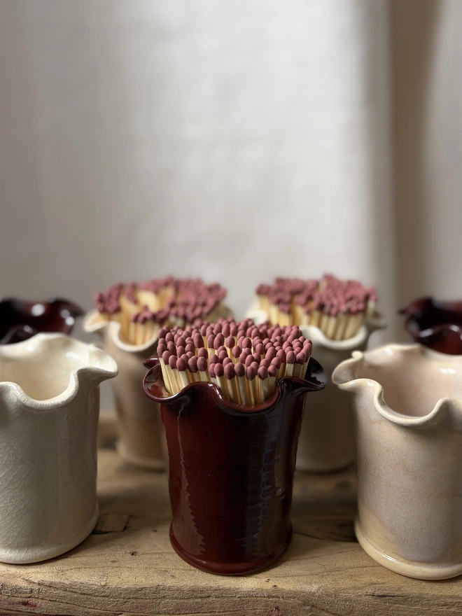 Collection of frilly matchstick pots in pink, red/burgundy and cream crackle with matches
