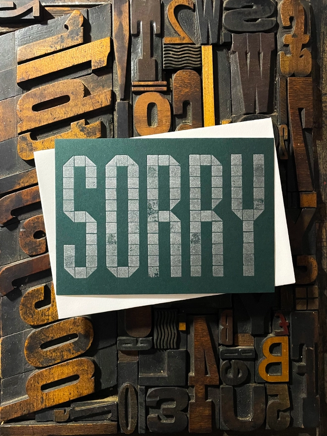 Sorry! A beautiful typographic letterpress postcard printed with metallic silver inks printed on rich thick  colourful card; ideal to send a sympathy note to a friend or loved one.