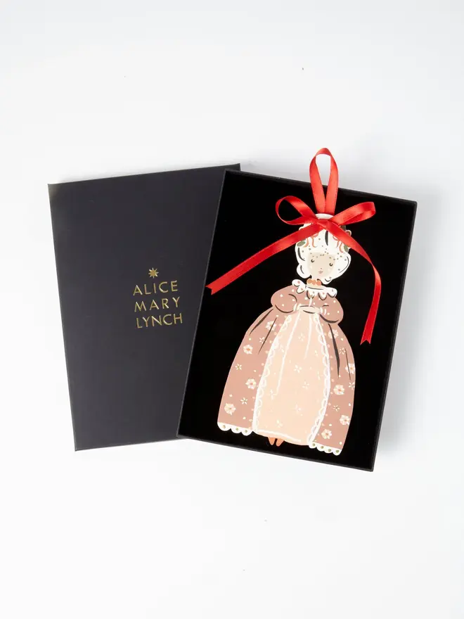 Christmas Princess Tree Dancer. wooden hanging christmas princess decoration in an open black gift box embossed "alice mary lynch" in gold, with a floral crown, dusky pink floral gown and large red ribbon bow