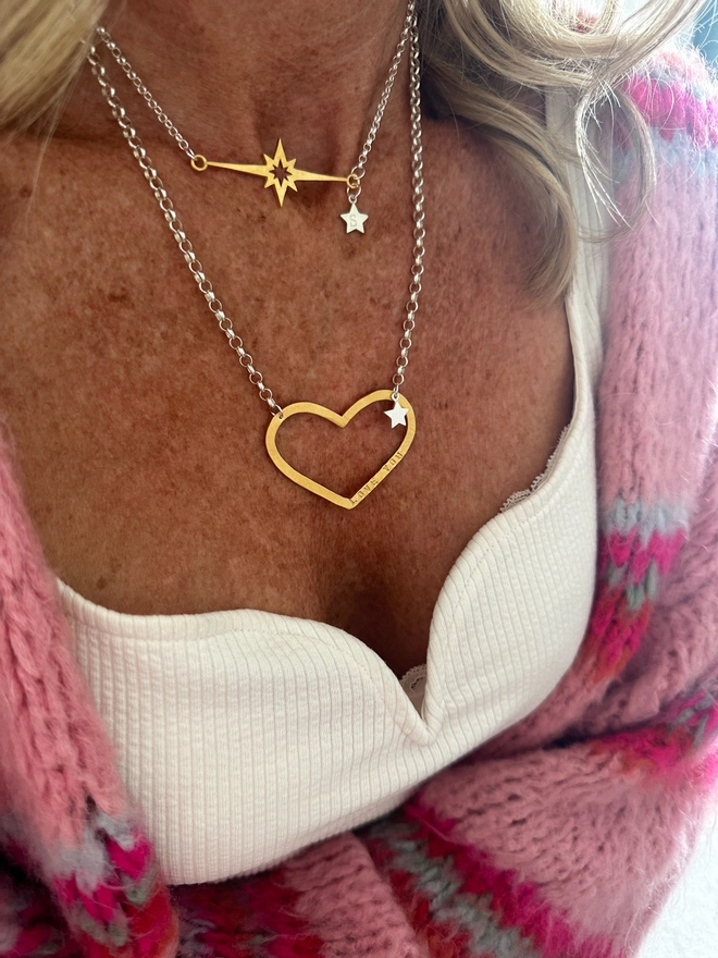 model wears a gold supernova star charm on a silver chain with silver mini star