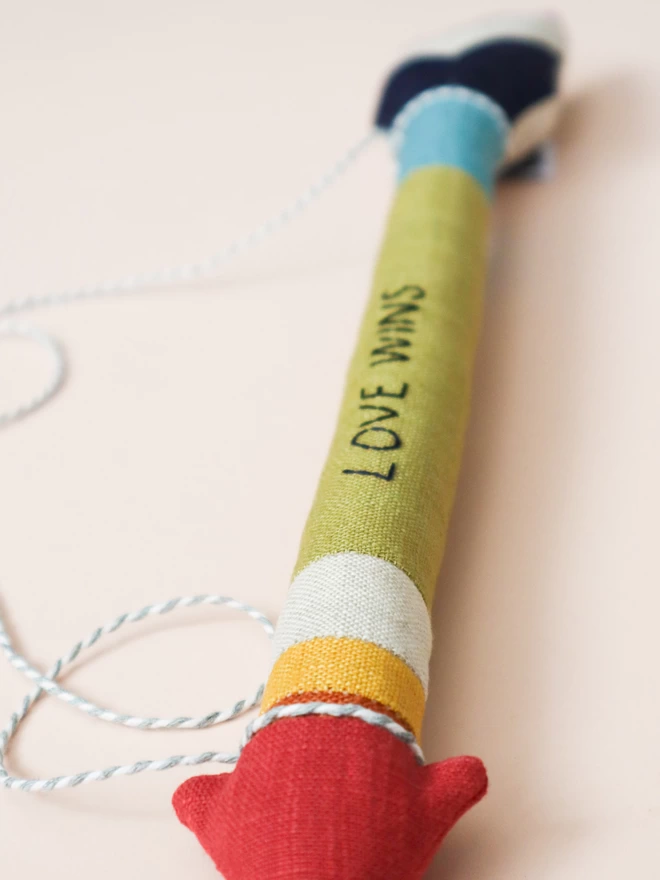 love wins enbroidery on rainbow coloured arrow decoration 