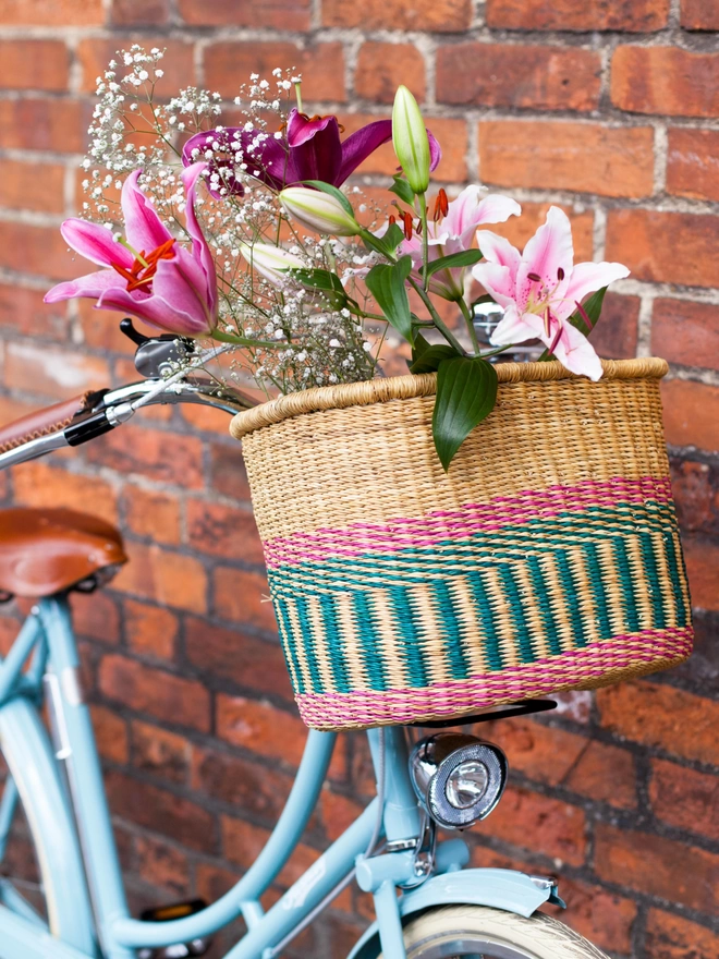 blue bike with woven bicycle basket styled with flowers
