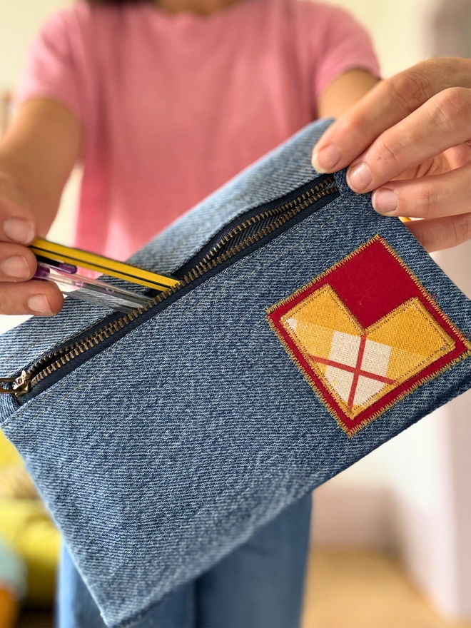 Handmade pencil case made from reclaimed denim with a zip fastening and a bright vintage‑print initial on the front