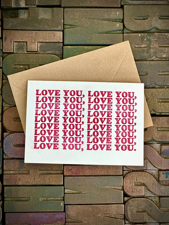 Love You letterpress printed card with Kraft envelope on wooden type background