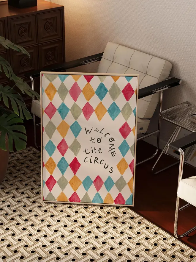 'welcome to the circus' art print. a print with a colourful diamond pattern background and a slogan in black letters. 