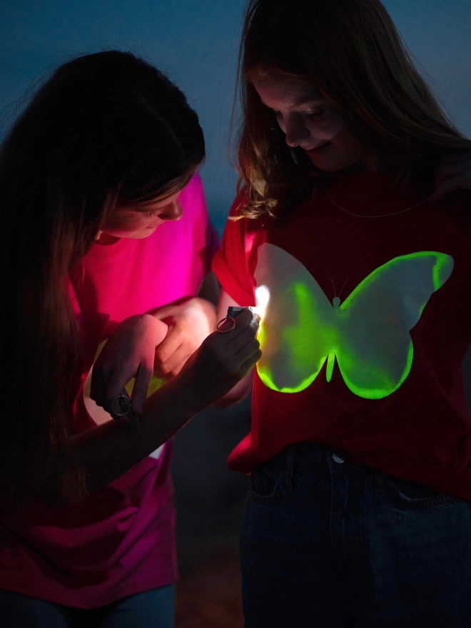 Two girls playing with butterfly glow in the dark tshirt