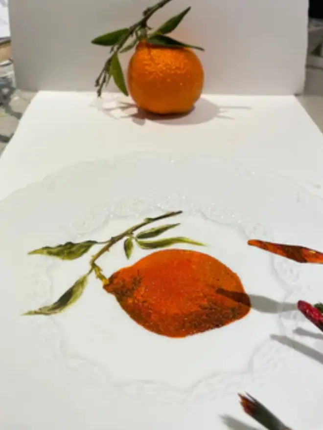 Oil Painted Orange On Antique Plate, in a studio next to paint and a real orange. 