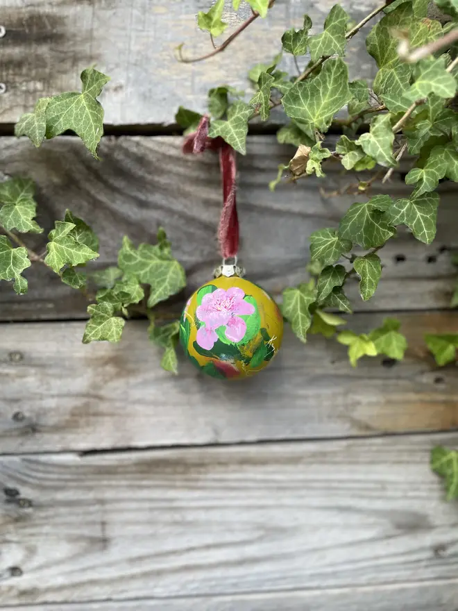 Unique hand-painted ceramic floral bauble featuring pink paeonia flowers on a olive green background