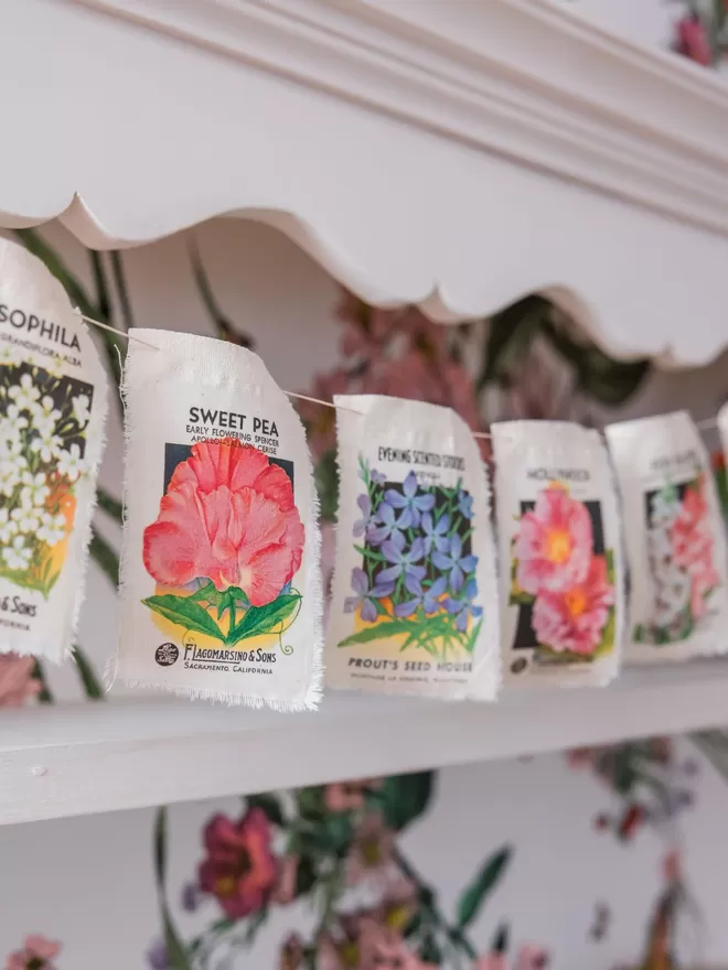 A length of vintage flower seed packet bunting with poppy, foxglove and cosmos
