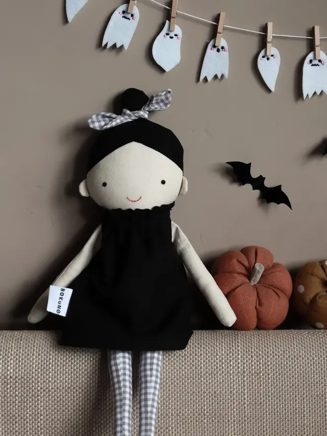 marrie top knot girl doll. a linen doll with a black dress and hair tied up with a grey bow.