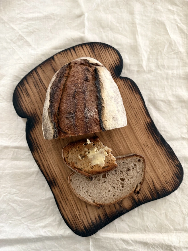 Large toast shaped serving board oak with charred edges with bread and butter