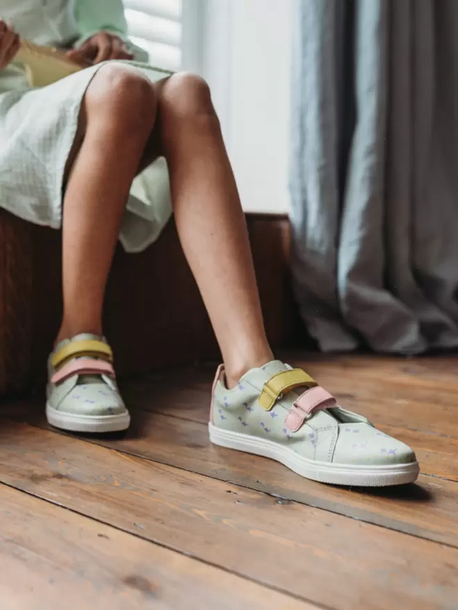 Little girl wearinf mint coloured dinosaur print Pip and Henry Trainers