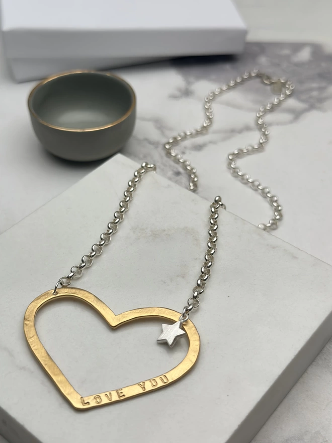 Large personalised gold open heart charm on a sterling silver chain, with a small silver star charm beside the heart