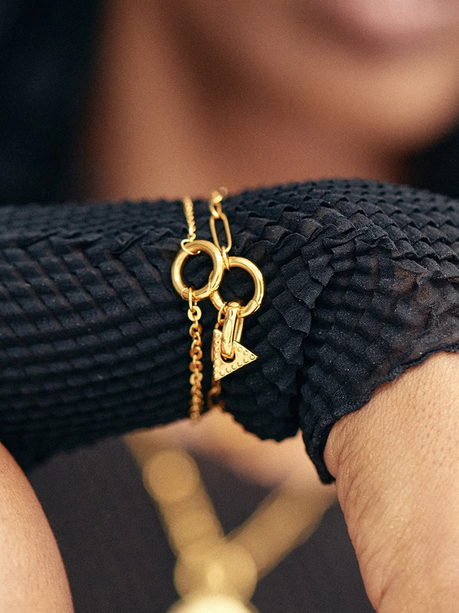 woman wearing gold bracelets with charm