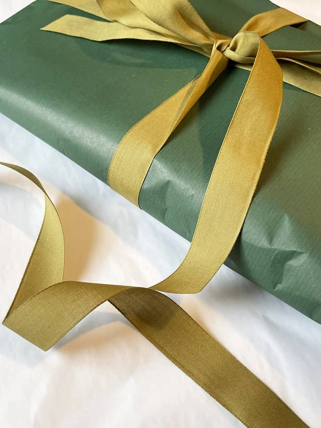 merino wool walking sock - grey blue. green tissue wrapping paper with a gold ribbon. 