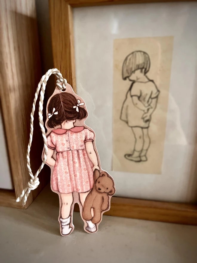 a swing tag of a little girl with bunches drawn from behind in a story book style illustration