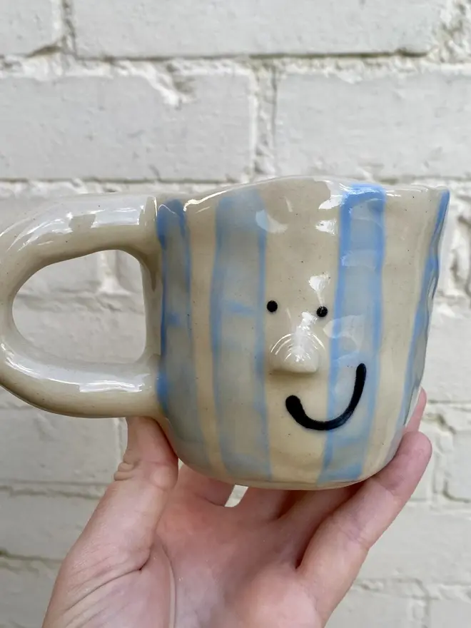 handmade ceramic smiley face blue white strip mug