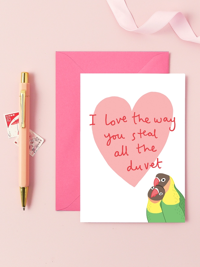 A funny valentine's card featuring two love birds. 'I love the way you steal all the duvet'.