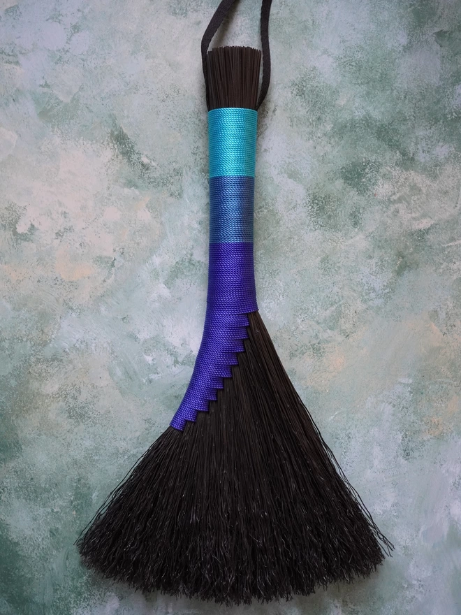 Black broomcorn handbroom with blue nylon cord binding