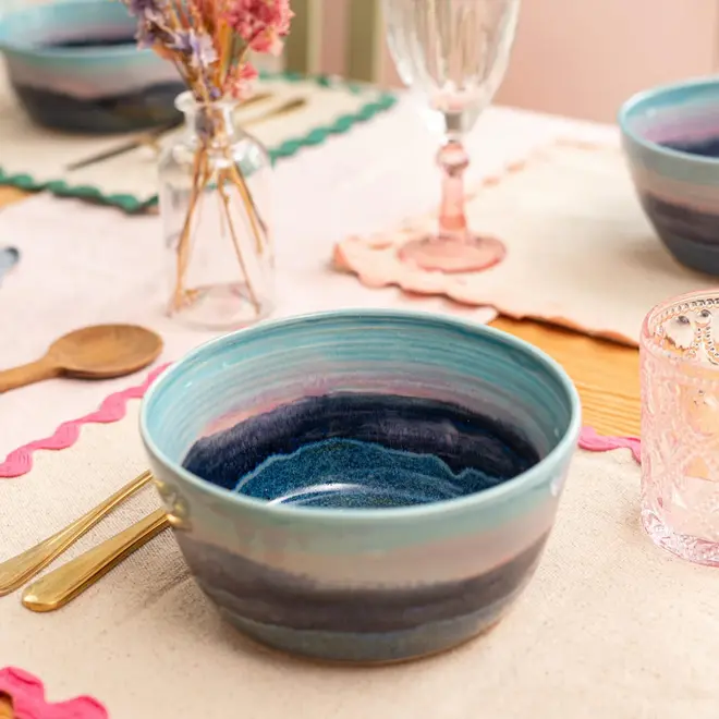 Landscape Ramen Bowl, a colourful table decorated with bowls, utensils and napkins. 