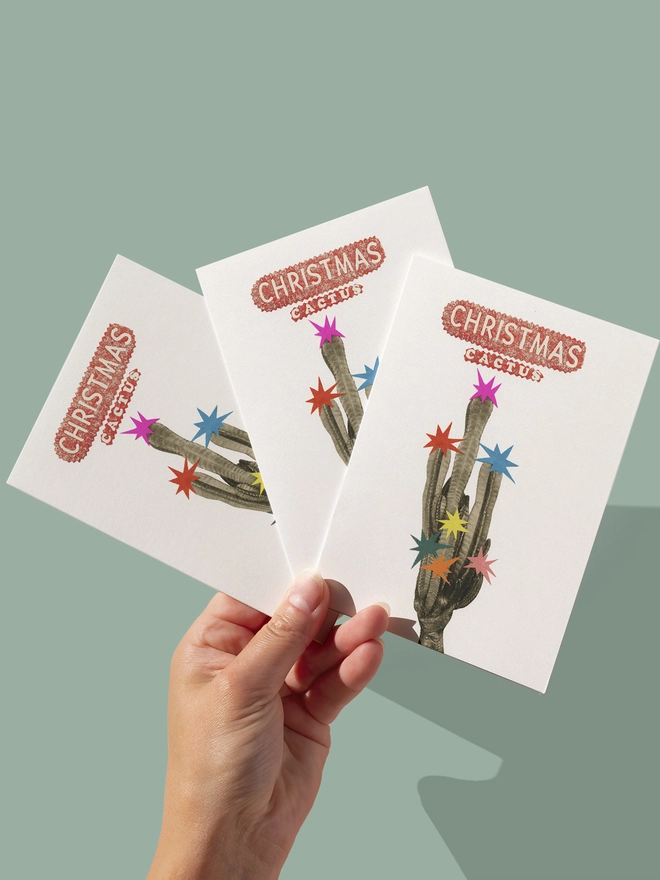 A vibrant, retro Christmas card featuring a tall cactus decorated with colourful stars.
