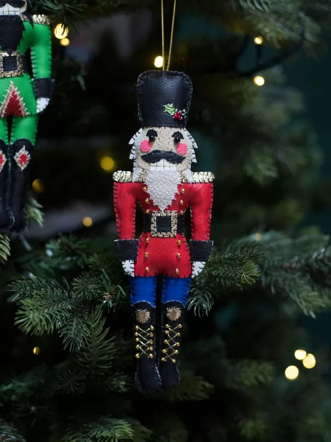Hetty and Dave red leatherette hand stitched nutcracker decoration hanging on a Christmas tree