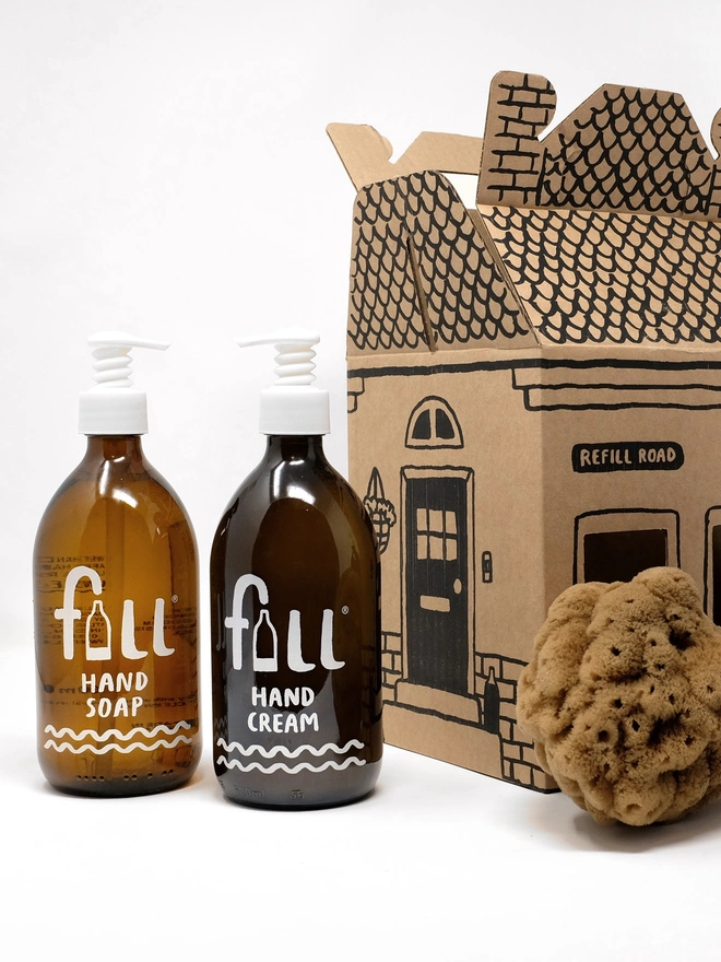 Go Fig & Go Home. A box shaped like a house, with three amber glass bottles sat next to it.